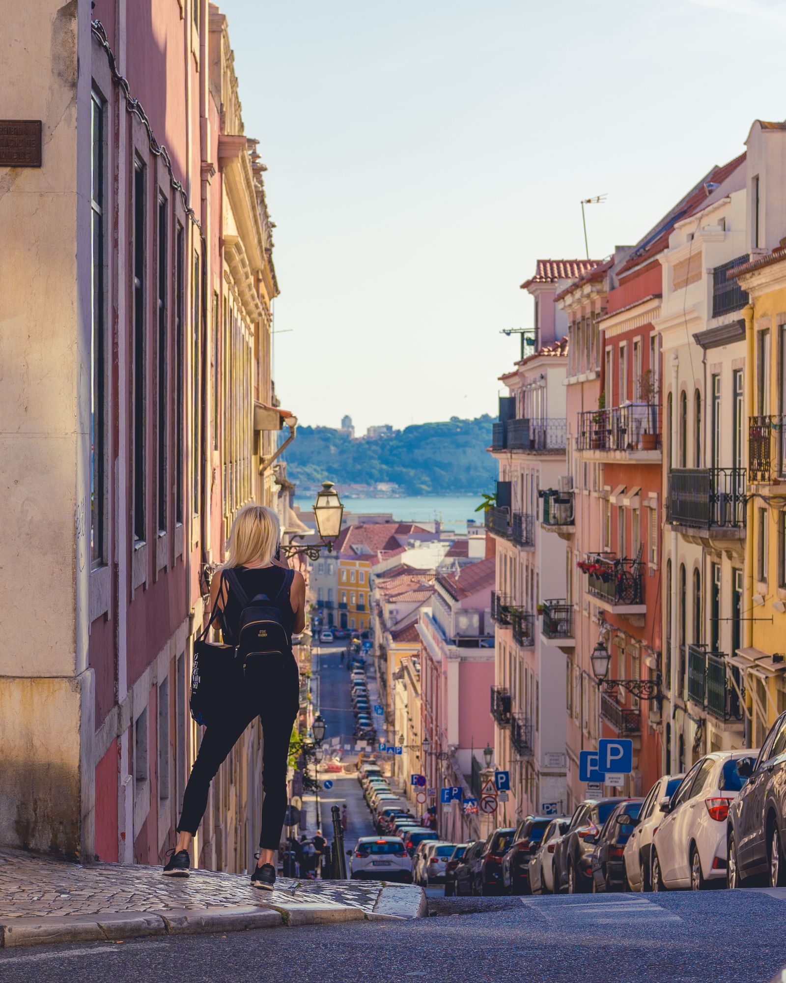 A young traveler with a backpack exploring sunlit streets in Lisbon